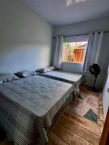two beds in a room with a window at Recanto Paraiso Tropical- Praia Ajuruteua in Bragança