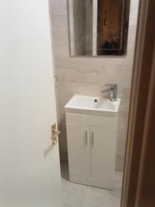 a white bathroom with a sink and a mirror at Cozy stay in Dublin +8 photos
