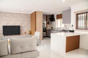 a kitchen and living room with white furniture and a flat screen tv at Ipanima palace in New Germany