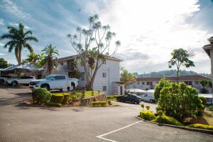 a parking lot with cars and palm trees and a building at Ipanima palace in New Germany