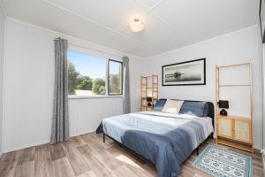 a bedroom with a bed and a large window at Blue View - Ocean Views For Miles in Guilderton +20 photos