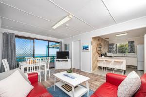 a living room with a red couch and a table at Blue View - Ocean Views For Miles in Guilderton