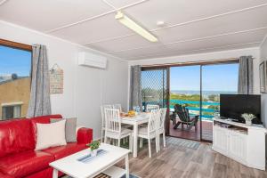 a living room with a red couch and a table at Blue View - Ocean Views For Miles in Guilderton