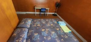a bedroom with a bed and a table with a fan at Haekua Chez Mel in Nuku Hiva