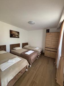 a room with three beds and a dresser at Aurea Novi 3 in Herceg-Novi