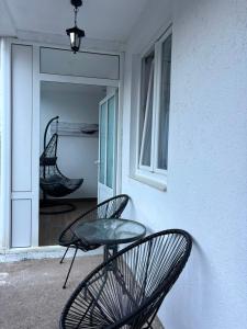 a patio with two chairs and a table and a window at Aurea Novi 3 in Herceg-Novi