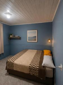 a bedroom with a bed in a blue wall at Destiny home in Curitiba