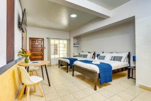 two beds in a room with a table and chairs at Hill Garden Boutique Resort in San Ignacio +88 photos
