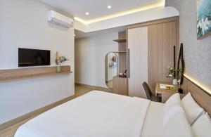 a hotel room with a bed and a tv at LUNA Hotel in Vĩnh Long