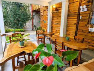 a restaurant with wooden tables and chairs and plants at FRANKFURTER HOF FAMILIAR Oxapampa in Oxapampa