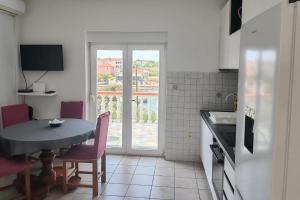 a kitchen with a table and a dining room table at Apartment Ugljan 846b in Ugljan