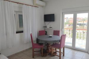a dining room with a table and chairs and a window at Apartments by the sea Ugljan - 846 in Ugljan