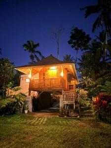a tree house with a deck at night at Dopi Rinjani Homestay in Tetebatu