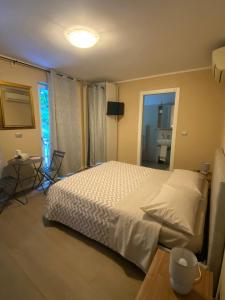 a bedroom with a white bed and a window at AFFITTACAMERE PIAZZA UNITA' in Monfalcone