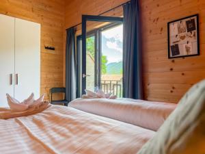 two beds in a room with a window at Rattendorf 22A in Rattendorf