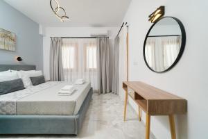 a bedroom with a bed and a mirror and a table at Lumina House Panagia in Panagia