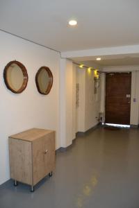 a hallway with two mirrors on the wall and a wooden cabinet at Kaza Living Usaquén in Bogotá +12 photos