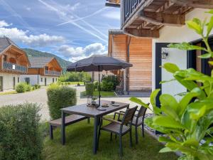 a table and chairs with an umbrella on a patio at Rattendorf 22A in Rattendorf