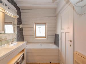 a bathroom with a tub and a sink and a window at Tuzzetje in Nieuwpoort +13 photos