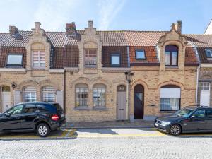 two cars parked in front of a brick building at Tuzzetje in Nieuwpoort