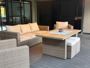 a living room with a table and wicker chairs at Waterlink Retreat in South Yunderup