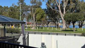 a park with a fence and trees and water at Waterlink Retreat in South Yunderup