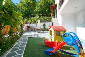 a small playground with a slide and a toy house at Lumina House Panagia in Panagia