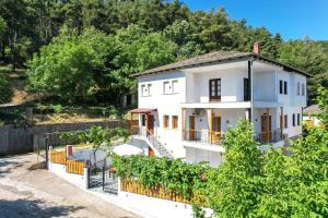 a white house with a fence and trees at Lumina House Panagia in Panagia