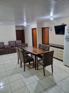 a dining room with a wooden table and chairs at Casa Da Chácara in Prudentópolis