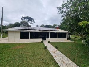 a house with a solar roof on top of it at Casa Da Chácara in Prudentópolis