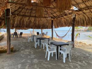 a group of tables and chairs on the beach at HOTEL ALMARr in Coveñas