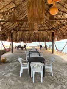 a table and chairs under a straw umbrella on the beach at HOTEL ALMARr in Coveñas +18 photos