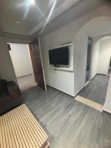 a living room with a flat screen tv and a couch at Résidence ADAM in Akouda