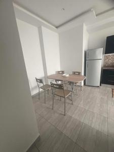a kitchen with a table and chairs and a refrigerator at Résidence ADAM in Akouda