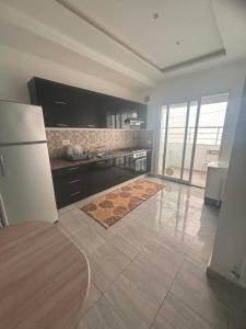 a kitchen with a refrigerator and a tile floor at Résidence ADAM in Akouda
