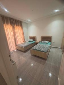 a room with two beds and a window at Résidence ADAM in Akouda +12 photos