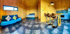 una sala de estar con un sofá azul y una mesa en Kahuna Surflodge, en Pichilemu