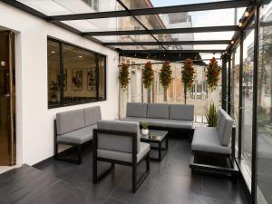 a patio with couches and chairs in a building at Hotel Embajada 44 in Bogotá
