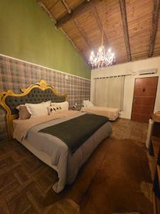 a bedroom with a large bed with a chandelier at Refugio MontSerrat in Urubici