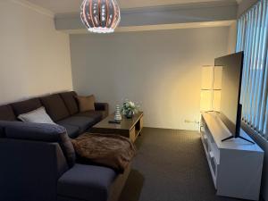 a living room with a couch and a tv at Sweet Single in Wellard