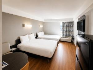 a hotel room with two beds and a television at Studio 6 Springfield VA Washington DC Southwest in Springfield