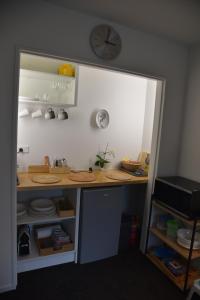 a kitchen with a counter and a clock on the wall at Rojan's Roost in Christchurch