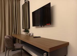 a room with a desk with a television on the wall at The Jerai Hotel Sungai Petani in Sungai Petani