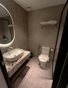 a bathroom with a sink and a toilet and a mirror at The Jerai Hotel Sungai Petani in Sungai Petani