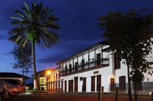 a white building with a palm tree in front of it at Donde Emma in Salamina