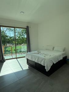 a bedroom with a bed and a large window at Hotel kleos in Cárdenas
