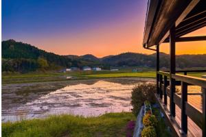 a house with a view of a river at sunset at Setouchi Retreats Sera Highlands in Egi