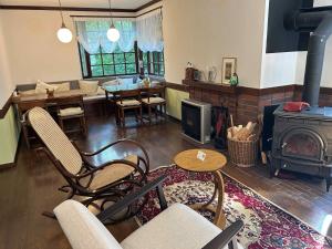 a living room with a wood stove and a dining room at Guesthouse Lavande in Chino