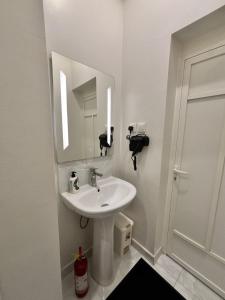 a white bathroom with a sink and a mirror at Olive home in Al Khobar