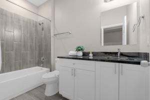 a white bathroom with a sink and a toilet at Brand New Themed Home With Lake View 11 in Davenport +23 photos